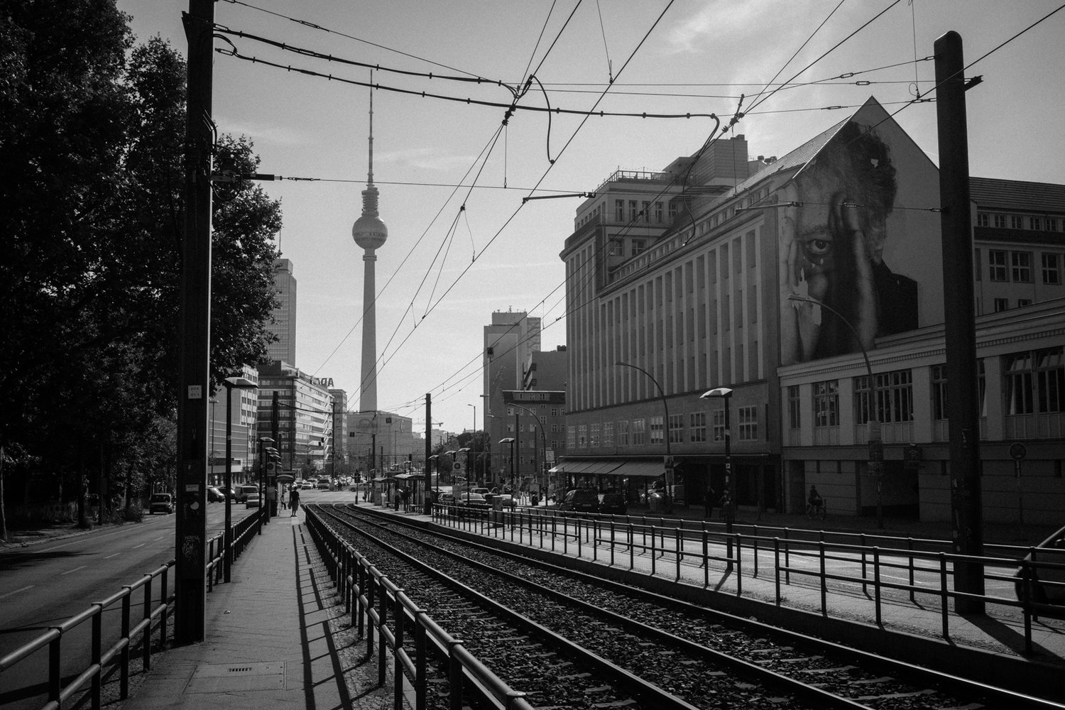prenzlauer allee berlin - streetcar tracks man looking mural tv tower